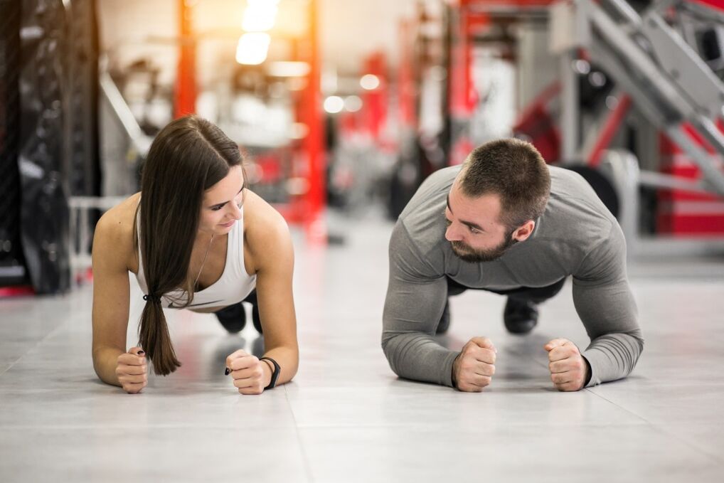 En mand og en kvinde udfører Plank-øvelsen, designet til alle muskelgrupper